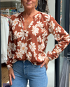 A tan top with white flowers 