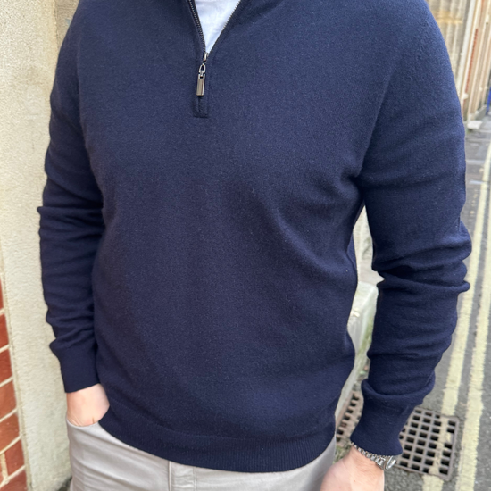 Male model wearing a navy cashmere quarter zip jumper.