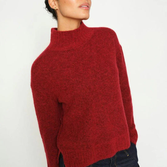 Woman wearing a red sweater against a white background