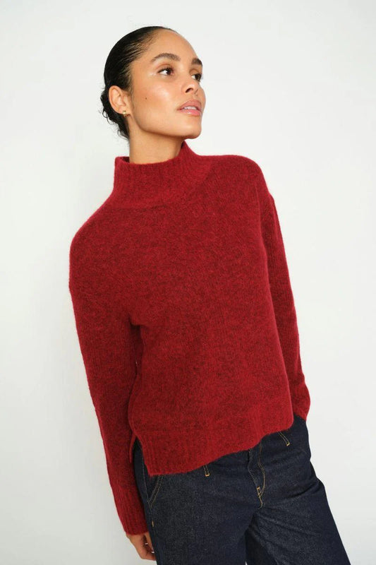Woman wearing a red sweater against a white background