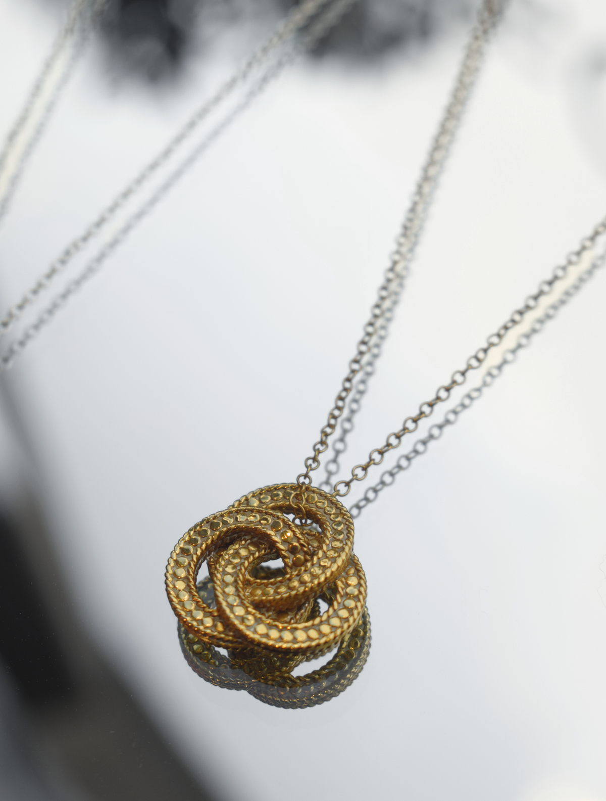 Three woven gold plated ring pendant on a gold chain