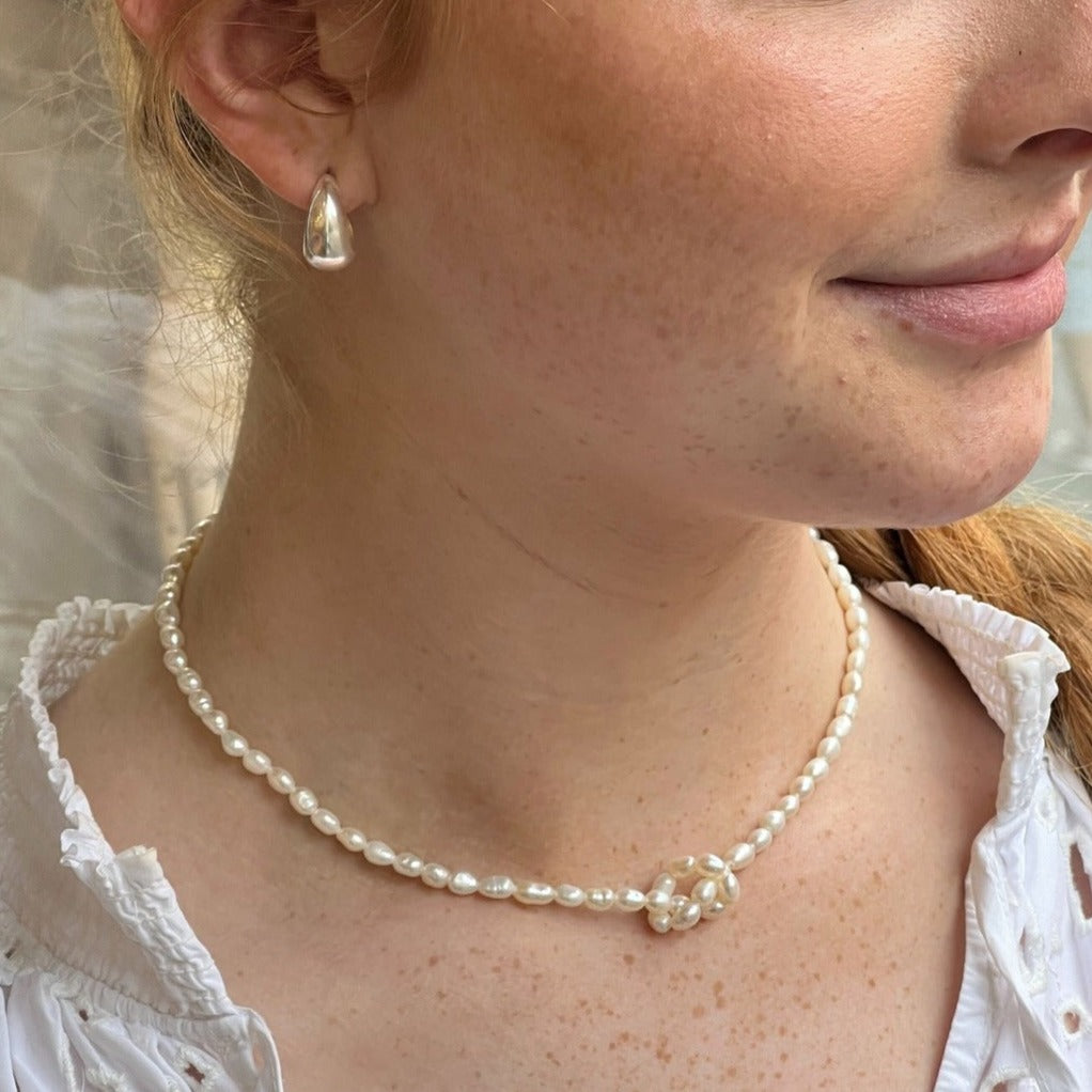 seed pearl necklace worn with a knot