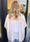 Person wearing a sheer white blouse and blue jeans