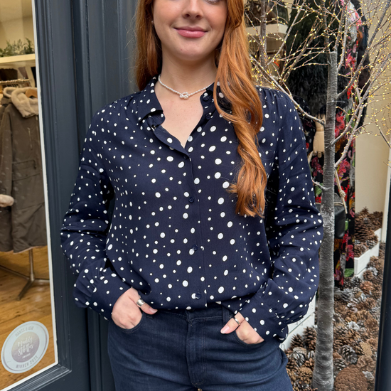 Navy long sleeved shirt with different sized white dots, styled with dark denim