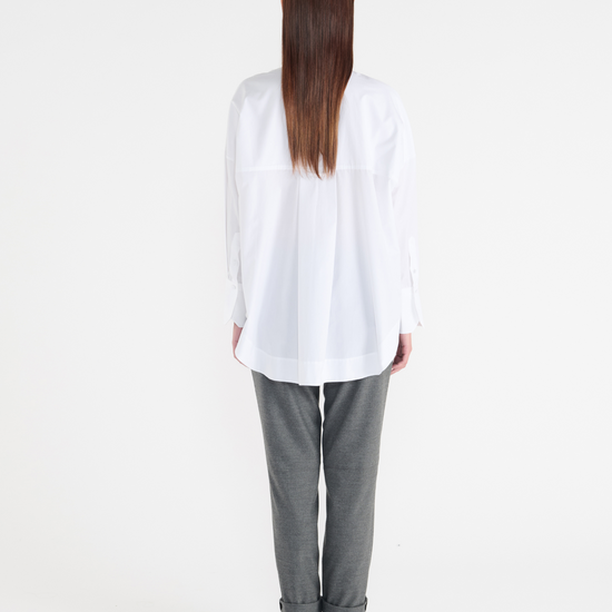 White long classic shirt with wide cuffs and panelling detailing on the front. Rear view.