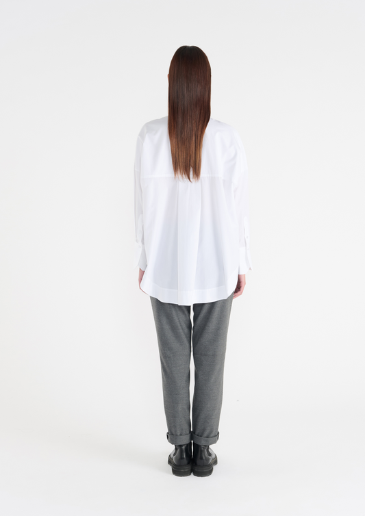 White long classic shirt with wide cuffs and panelling detailing on the front. Rear view.