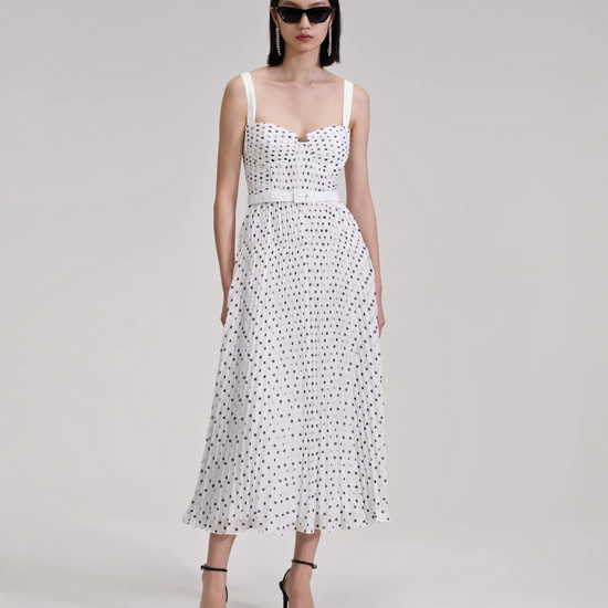 White and black polka dot midi dress with thin straps and fitted bodice with pleating throughout