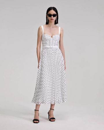 White and black polka dot midi dress with thin straps and fitted bodice with pleating throughout