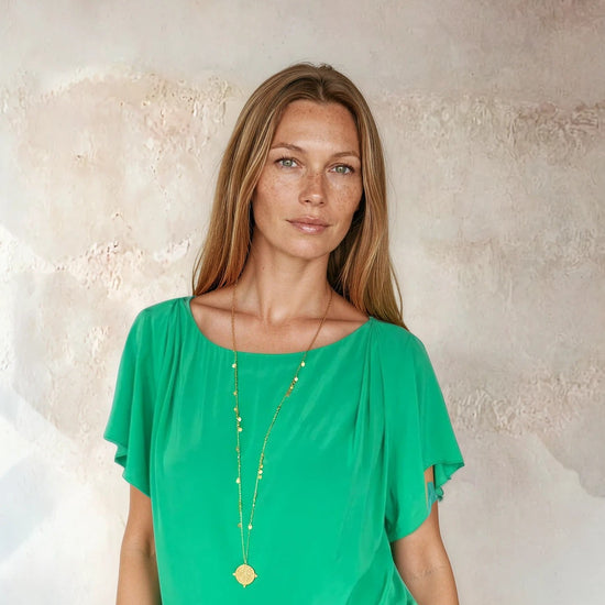 Green flutter sleeve top worn with blue jeans from Sirens