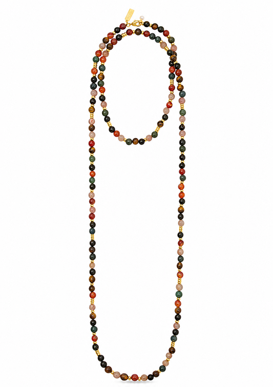 A long beaded necklace made of small round beads in multiple earthy colors including black, red, orange, green, beige, and white, with small gold spacer accents and a gold clasp, shown on a plain white background.
