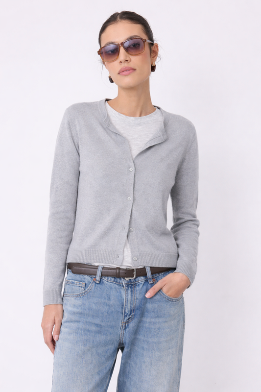 Woman wearing a cashmere gray cardigan, white shirt, blue jeans, and sunglasses on a light gray background from Not Shy