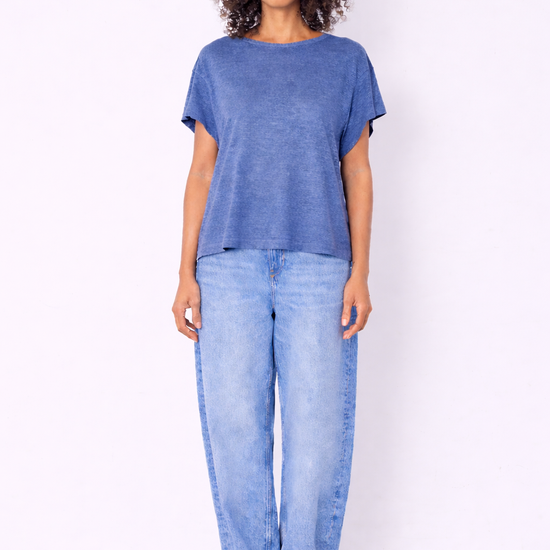blue top and jeans on model on plain background