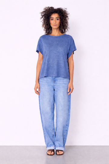 blue top and jeans on model on plain background