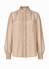 A beige long-sleeve blouse with a high lace-trimmed collar, scalloped lace placket, and lace cuffs, shown on a plain white background.