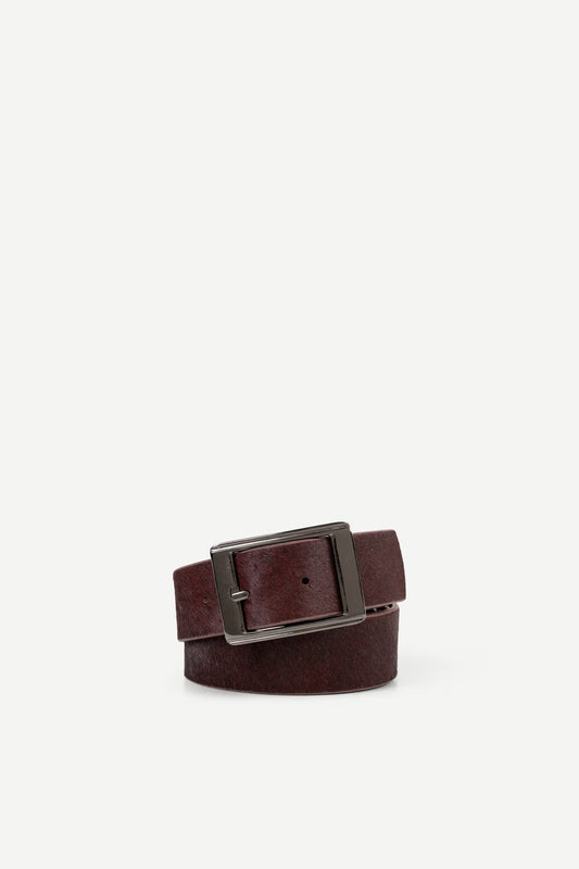 maroon leather belt with a silver buckle on a white background
