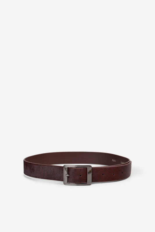 Maroon belt with a silver buckle on a white background