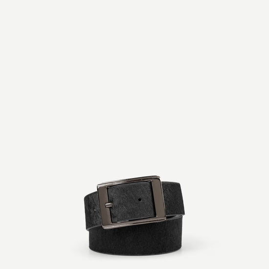 Blackhair on hide belt with a nickle buckle on a white background