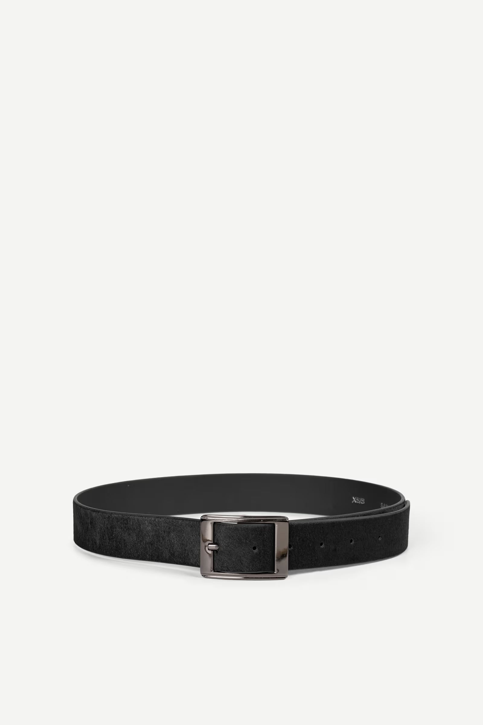 Black hair on hide belt with a nickle buckle on a white background