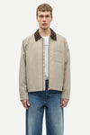 Man wearing a beige jacket with a brown collar by samsoe samsoe on a white background