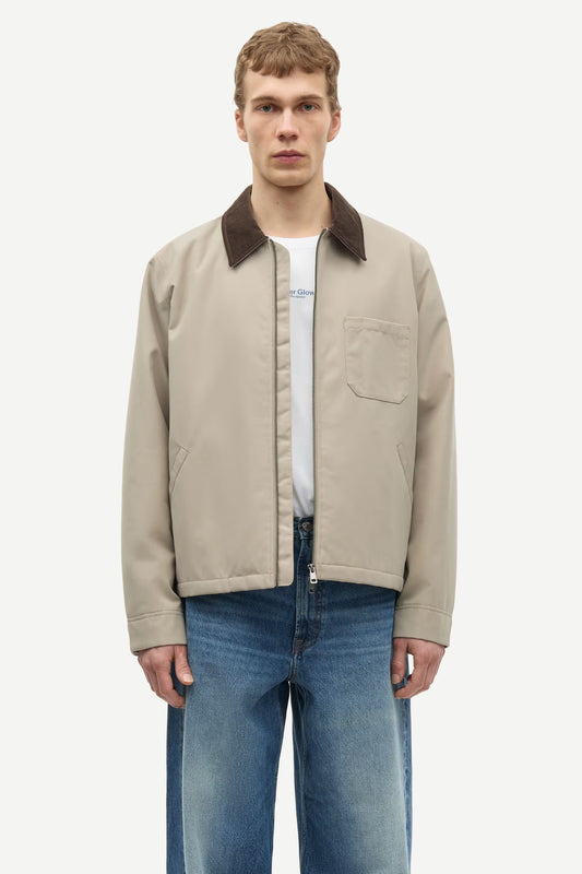 Man wearing a beige jacket with a brown collar by samsoe samsoe on a white background