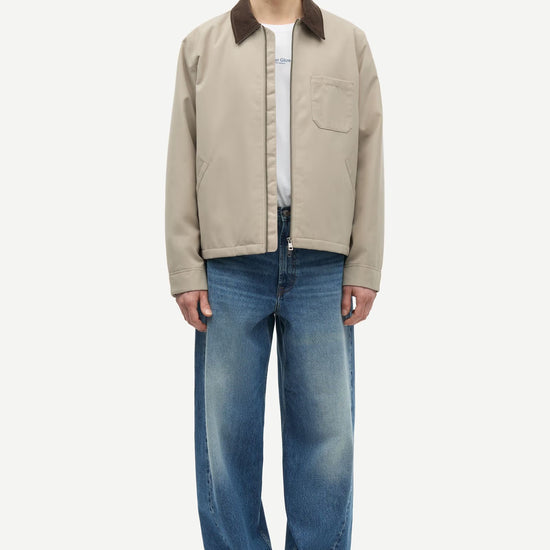 Man wearing a beige jacket with a brown collar by samsoe samsoe on a white background full outfit