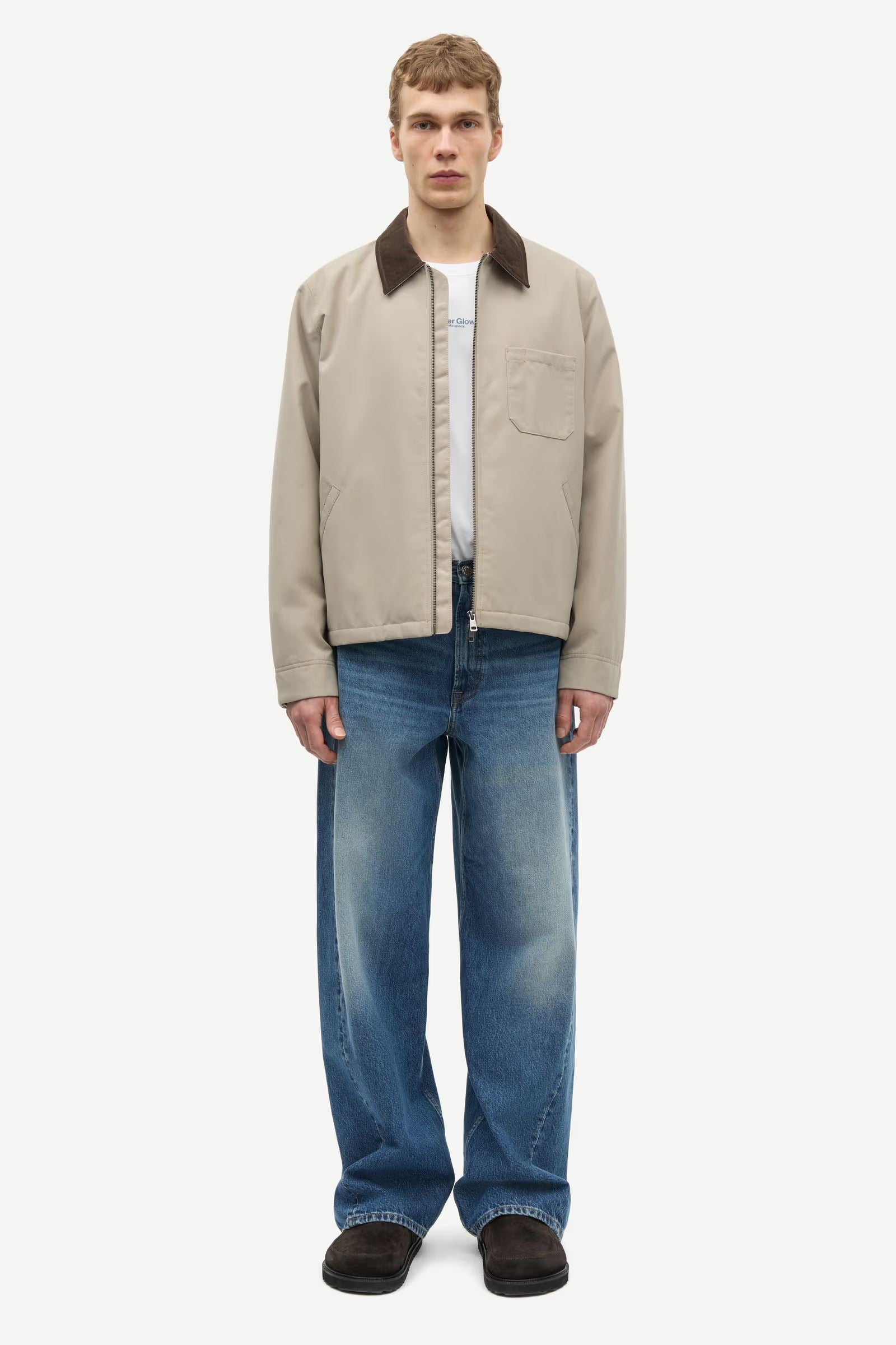 Man wearing a beige jacket with a brown collar by samsoe samsoe on a white background full outfit