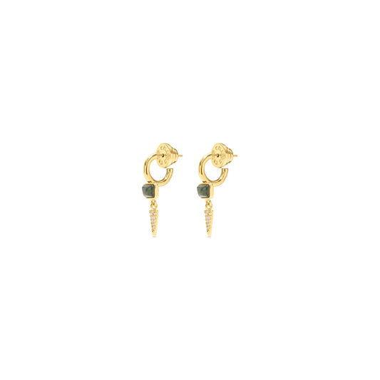 A pair of gold huggie hoop earrings with a small dark green square stone and a dangling gold cone charm embellished with tiny clear stones, shown on a plain white background.