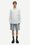 Man wearing a blue and white striped shirt by Samsoe Samsoe and denim shorts on a white background full outfit