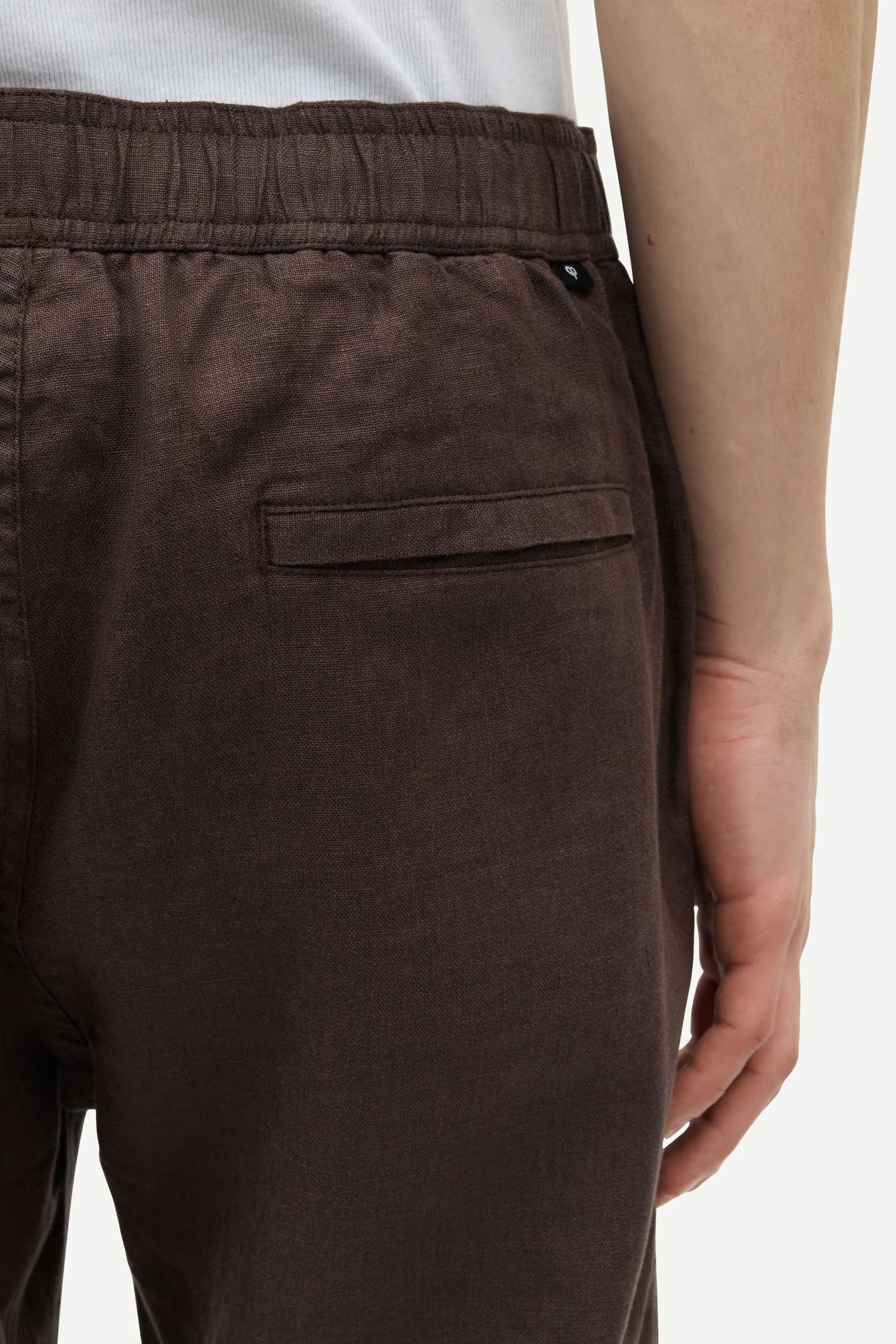 Brown pants by Samsoe Samsoe with a pocket on a white background