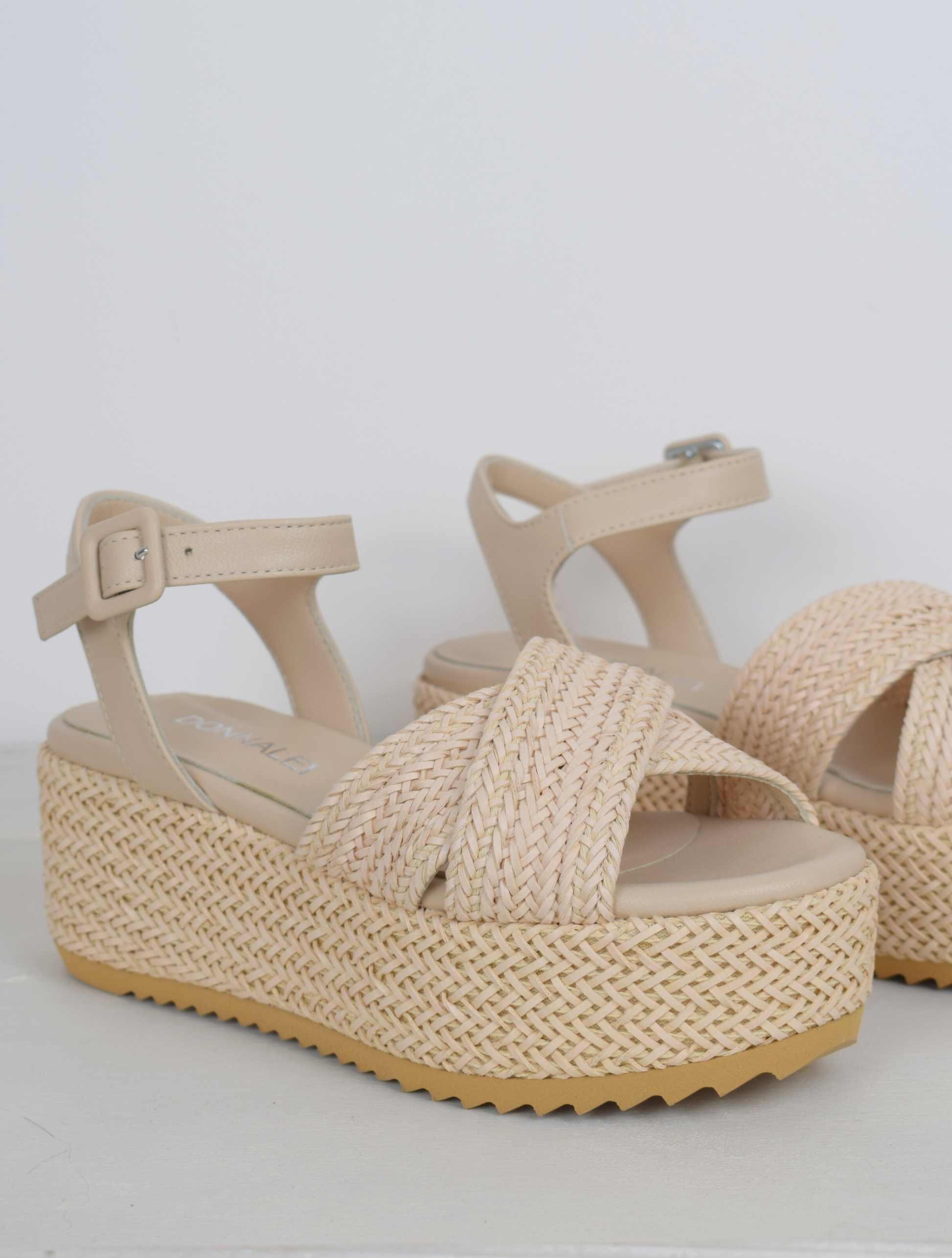 Blush coloured flatforms in a raffia