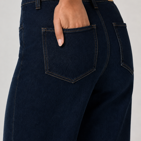 close up of the back pockets on a dark wash pair of jeans 