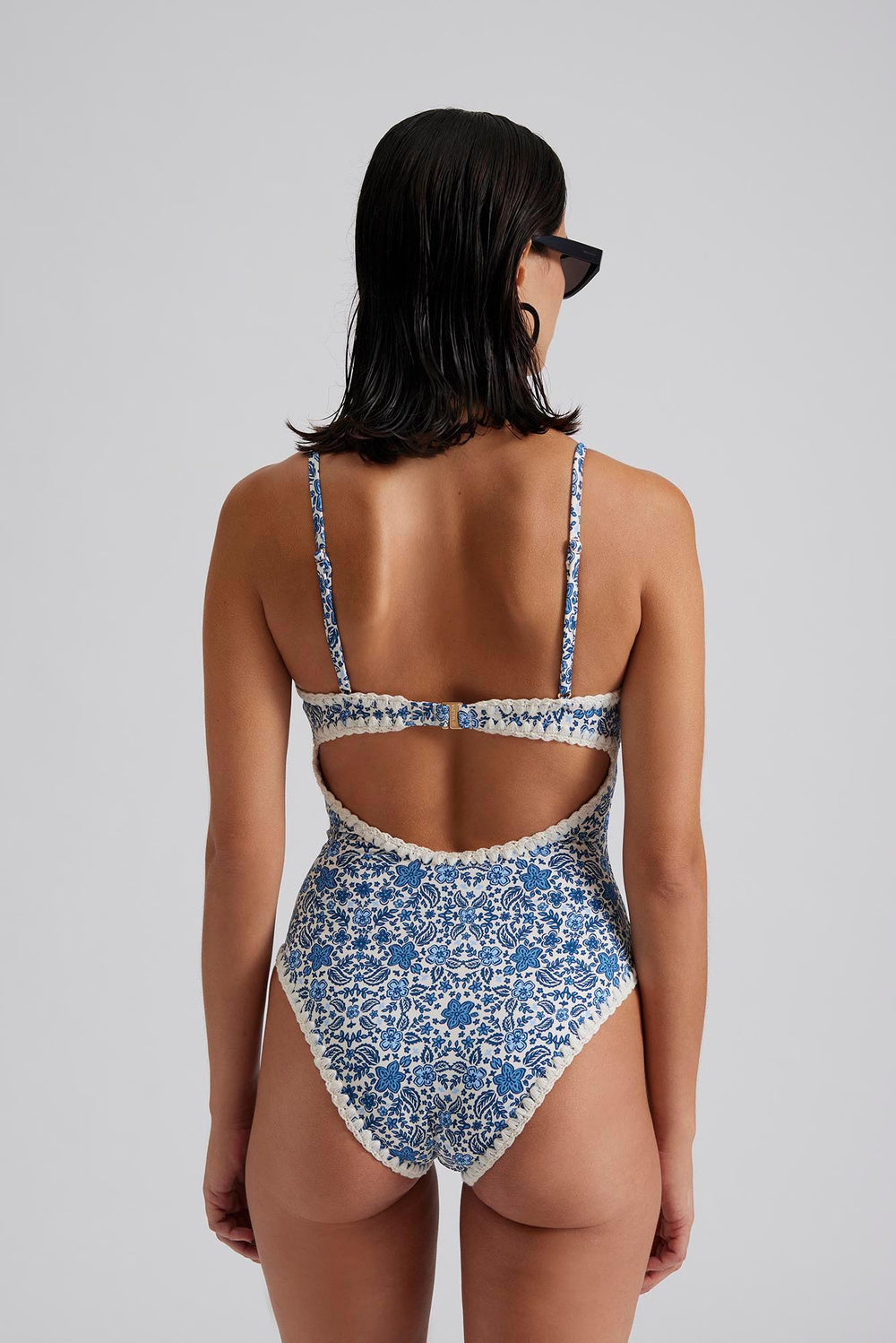 Blue and white floral swimming costume with thin straps crotched trim and open back