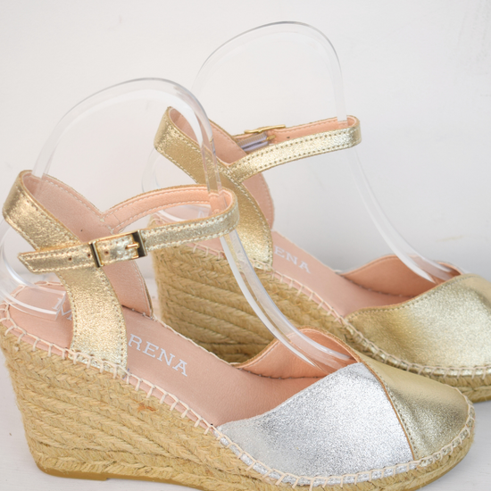 A raffia wedge sandal with a 2 tone top. Made up of silver and gold.