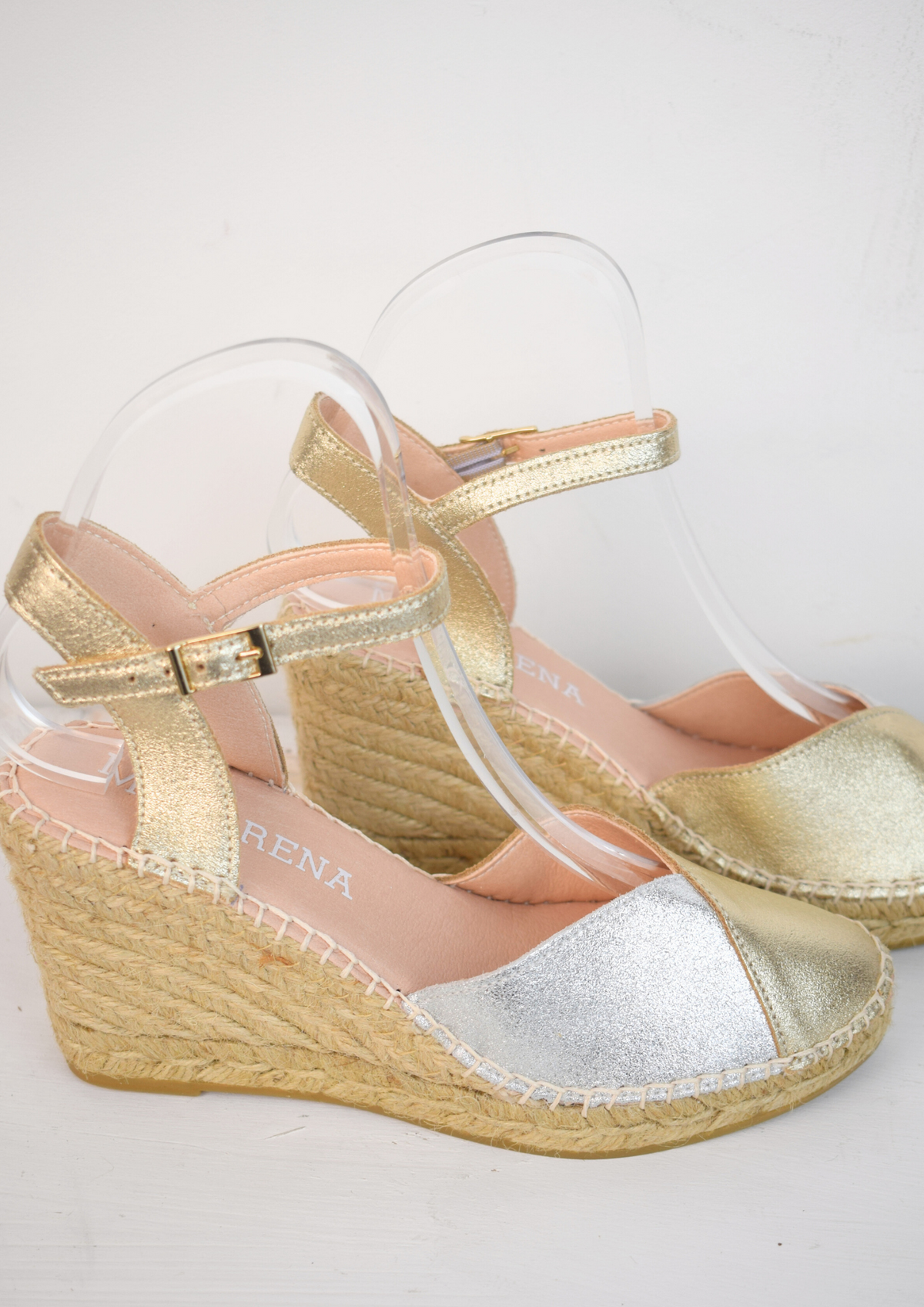 A raffia wedge sandal with a 2 tone top. Made up of silver and gold.