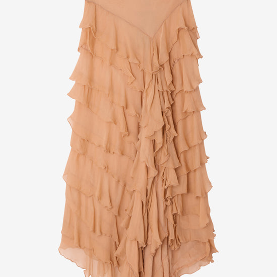 Tiered ruffle skirt in a shade of peach on a light gray background