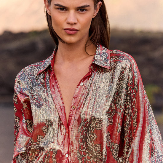 Woman wearing a patterned shirt with a blurred natural background