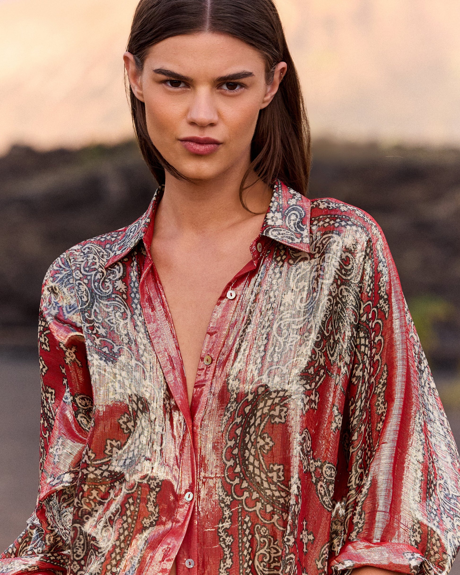 Woman wearing a patterned shirt with a blurred natural background