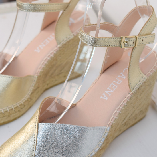 A raffia wedge sandal with a 2 tone top. Made up of silver and gold.