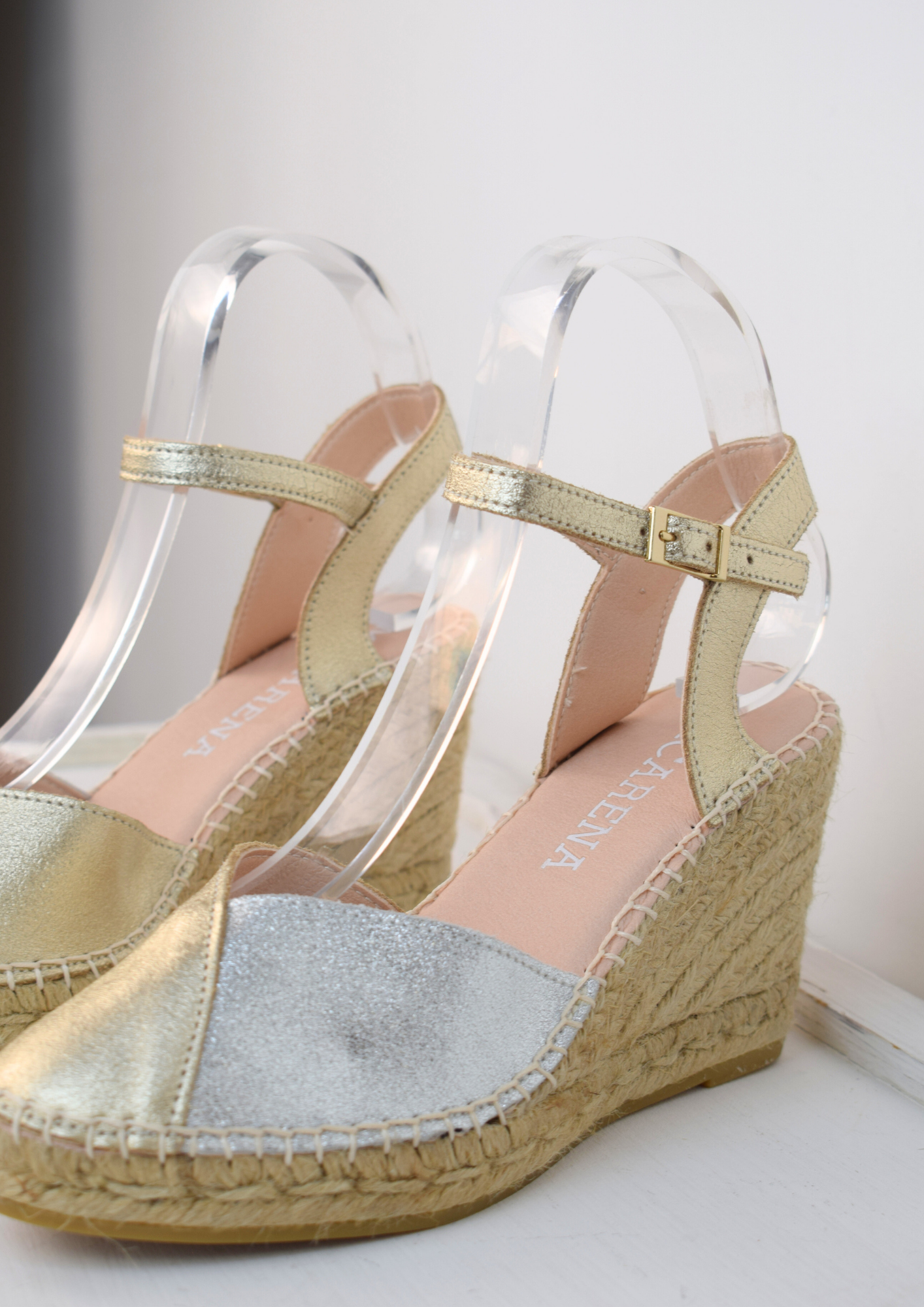 A raffia wedge sandal with a 2 tone top. Made up of silver and gold.