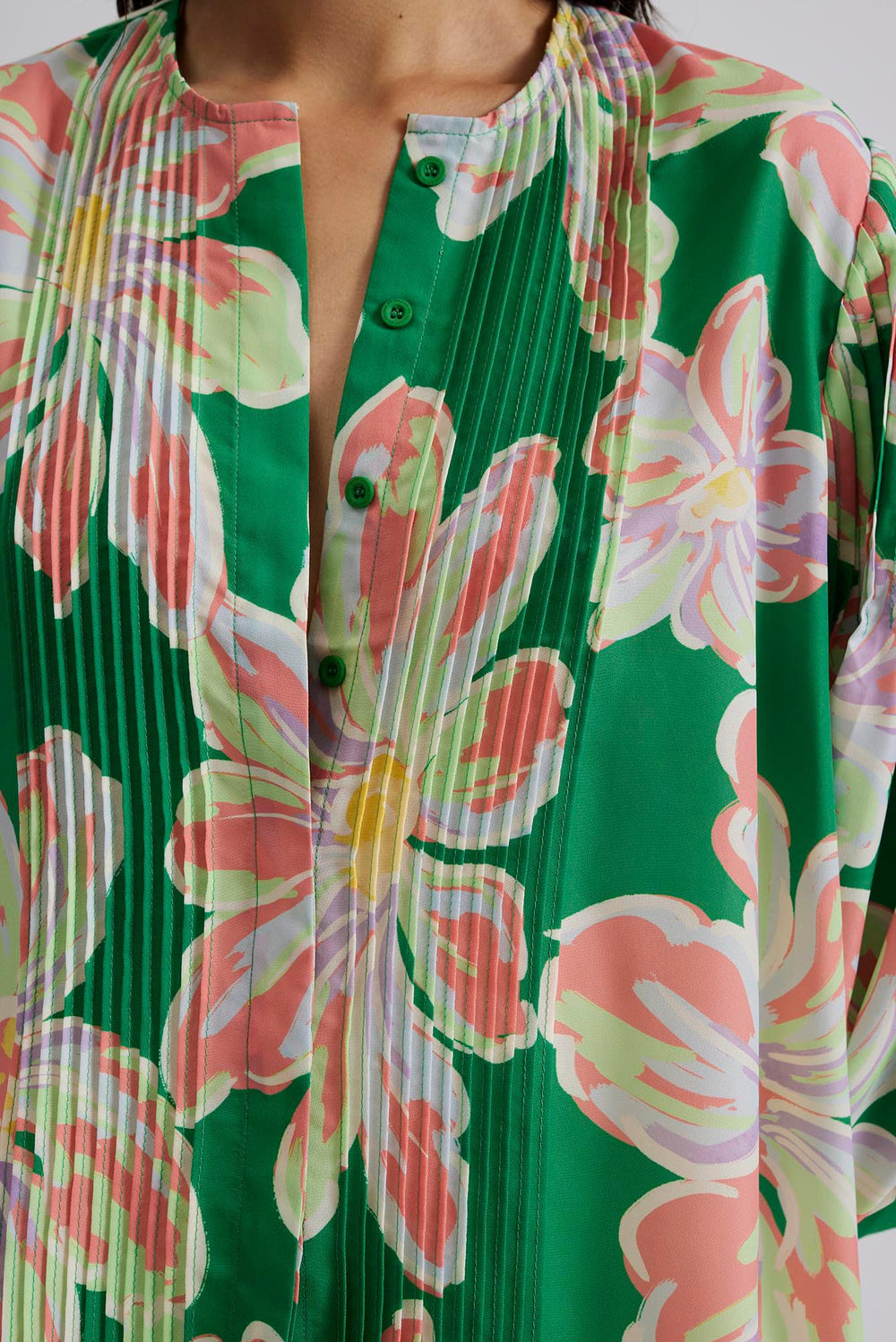 Green button through blouse with bold floral design and pink tuck features with long puff sleeves