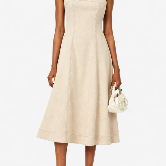 Woman wearing a ecru dress with white sneakers on a white background from Paige