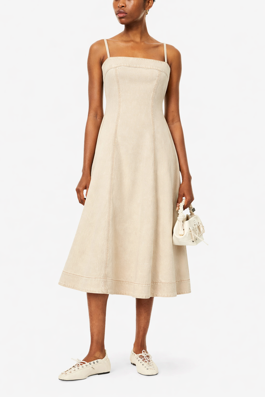 Woman wearing a ecru dress with white sneakers on a white background from Paige