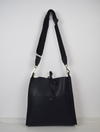 navy leather bag with cross body strap and small handle.
