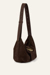Brown suede handbag with a strap on a beige background