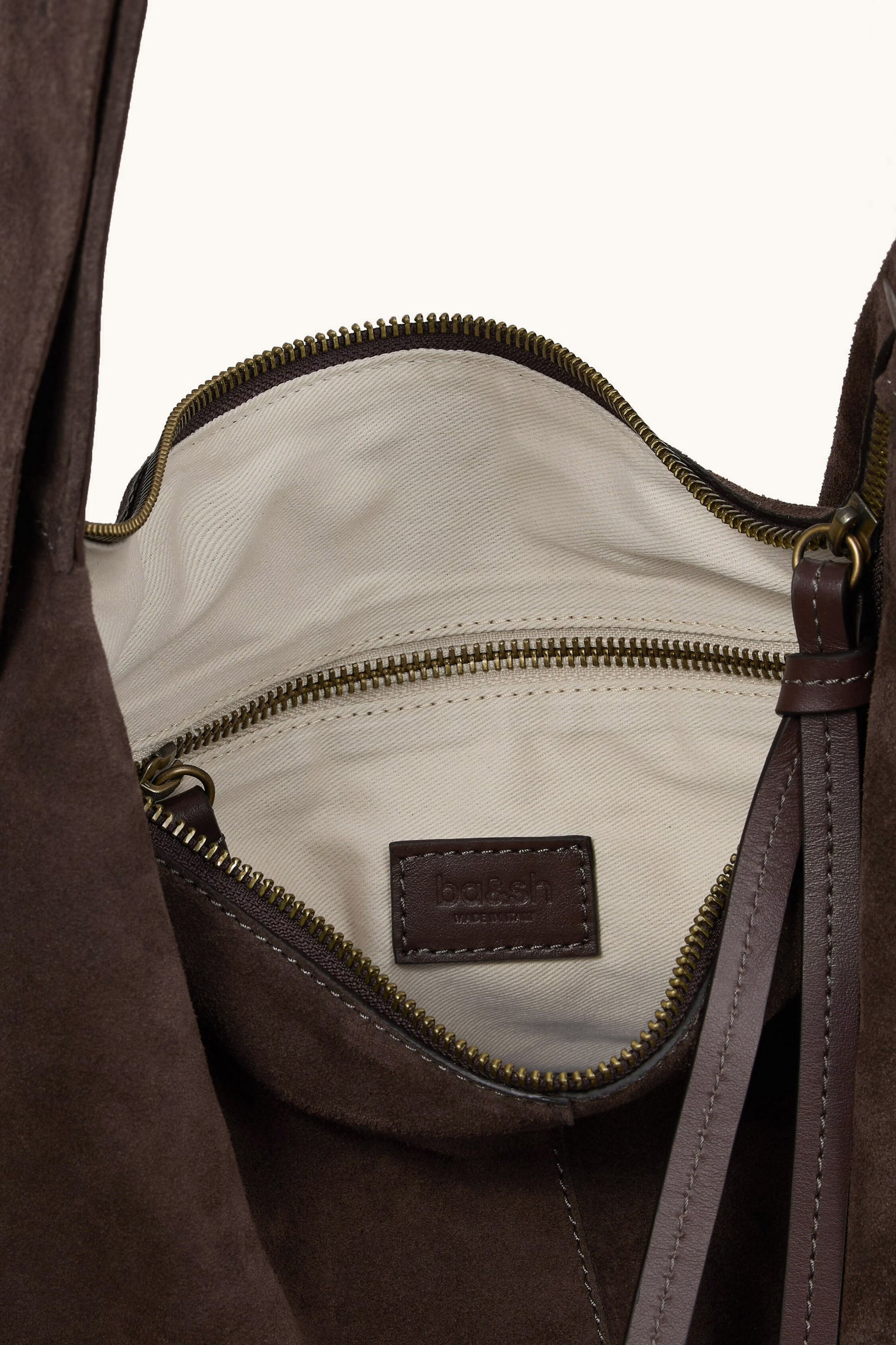 Brown leather bag with a visible brand label on a white background