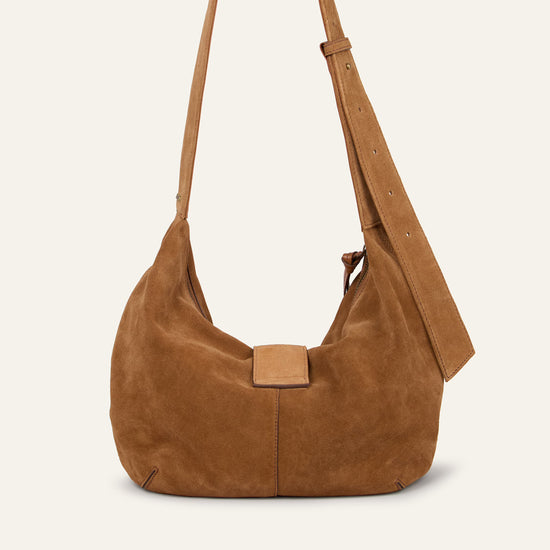 Brown suede handbag with a strap on a beige background from Ba&sh
