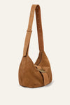 Brown suede handbag with a strap on a beige background