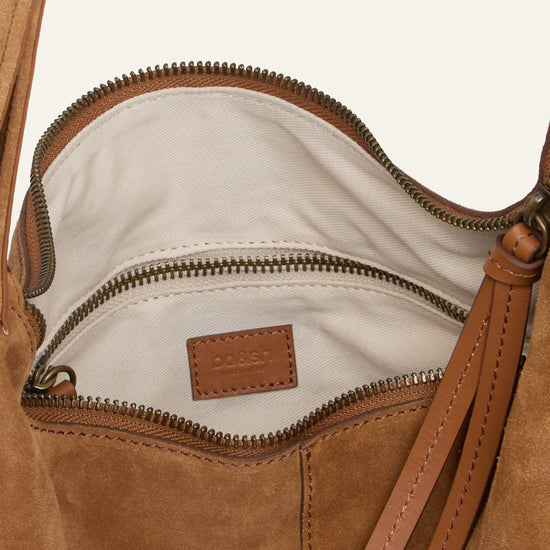 Close-up of a brown leather handbag with a visible brand logo.