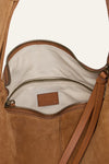 Close-up of a brown leather handbag with a visible brand logo.