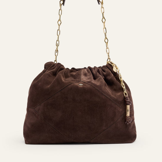 Brown suede handbag with gold chain handle on a white background